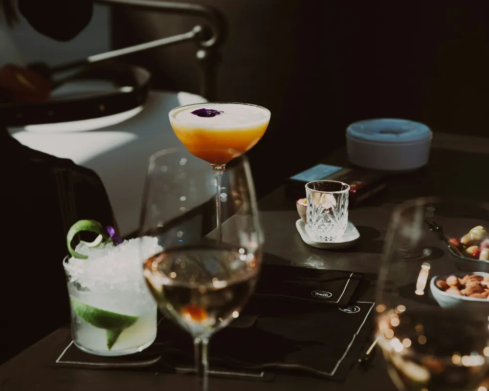 A bartender pouring a cocktail over ice